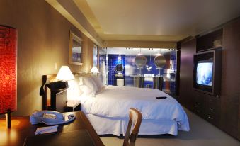 a large bed with white sheets and pillows is in a room with a desk , chair , and television at Novotel Montréal Centre