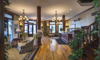 a hotel lobby with wooden floors , high ceilings , and large windows , decorated with green plants and chandeliers at The Inn at Wise