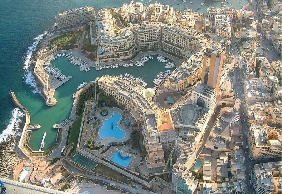 a bird 's eye view of a city with buildings , water bodies , and boats in the harbor at Alexandra Hotel