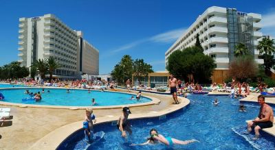 a group of people are swimming in a large pool near a hotel and other people sunbathing at Club Mac Club Mac - All Inclusive Family Resort Photo