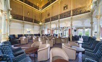 a large , elegant hotel lobby with multiple seating areas and a bar area , creating an inviting atmosphere at The Valley of Rocks Hotel