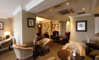 a cozy living room with various seating options , including couches , chairs , and a dining table at Macdonald Compleat Angler