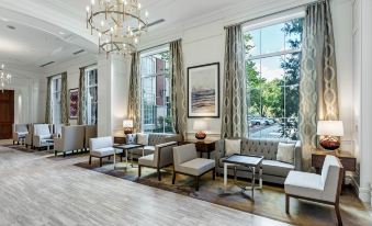 a spacious , well - lit lobby with multiple couches and chairs arranged around a coffee table , creating a cozy and inviting atmosphere at Hilton Columbus at Easton