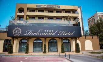 a hotel with a large sign on the front , advertising the richmond hotel , located in a city street at Richmond Hotel