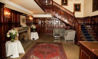 a wooden staircase with a red carpet leading up to the second floor of a building at Quorn Country Hotel