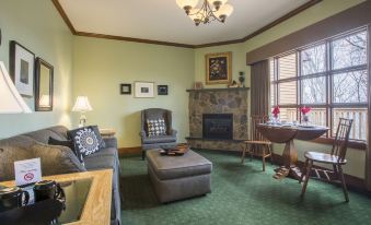 a cozy living room with a fireplace , comfortable seating , and a dining table in the background at Stroudsmoor Country Inn