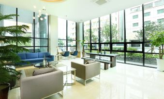 a modern living room with blue and gray furniture , large windows , and a view of the outdoors at Hotel the One