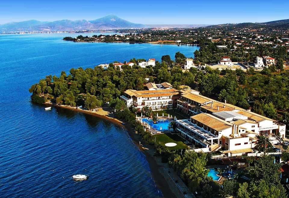 a large body of water with a resort on the shore and mountains in the background at Negroponte Resort Eretria