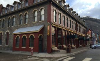 a large , ornate building with a red roof and white trim is situated on a street corner at Grand Imperial Hotel