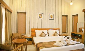 a hotel room with a large bed , two nightstands , and a table , all decorated in neutral colors at Graces Resort