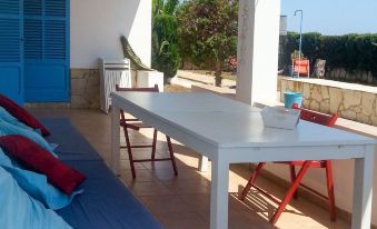 a white table and chairs are set up on a patio , overlooking the ocean at Casa Amigos