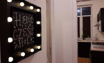 a hallway with a mirror on the wall and a blackboard hanging on the wall at Downtown Apartments
