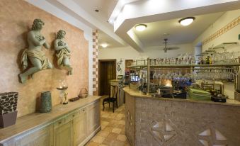 a restaurant with a dining area and a kitchen , featuring a counter with two statues on it at Villa Rosa