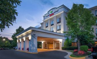 "a large hotel with a covered entrance and a sign that says "" holiday inn express ""." at SpringHill Suites Centreville Chantilly