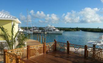a wooden deck overlooks a marina with boats docked in the water , creating a picturesque scene at Spanish Wells Yacht Haven