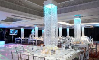 a large dining room with multiple tables and chairs , some of which are adorned with crystal columns at Westminster Hotel