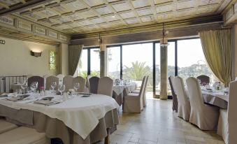 a well - decorated dining room with tables and chairs arranged for a large group of people at Chateau le Cagnard