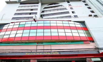 a tall building with a large sign on the side , indicating that it is a high - rise office building at Richmond Hotel Sylhet