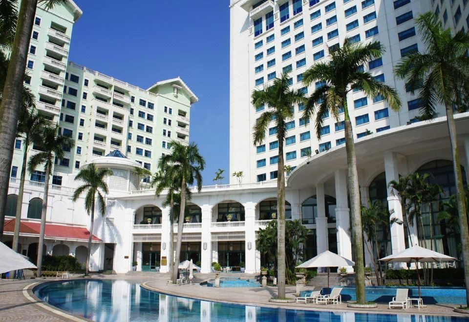 There is an outdoor building with two pools in the front and one on the other side at Hanoi Daewoo Hotel