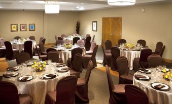 a large dining room filled with tables and chairs , ready for a formal event or a banquet at Hotel-Musee Premieres Nations