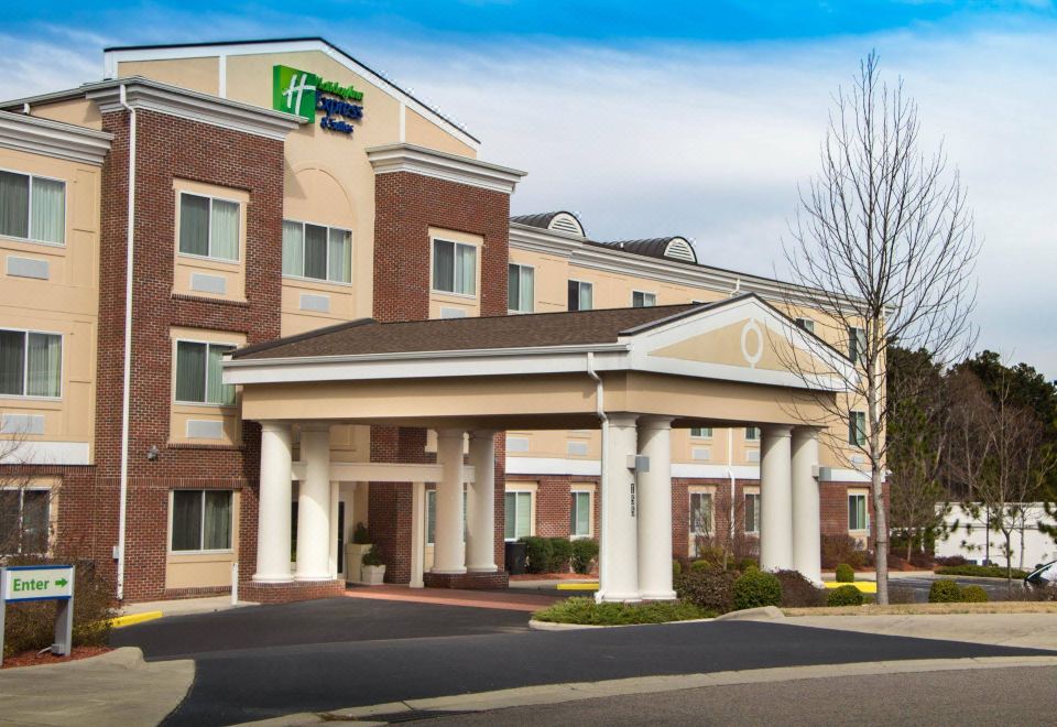 "a large hotel with a red brick exterior , and a sign for the hotel "" holiday inn express "" on the building" at Homewood Suites by Hilton Olmsted Village (Near Pinehurst, NC)