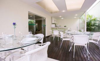 a modern kitchen and dining area with white chairs , a wooden floor , and large windows at Verona Hplus Long Stay