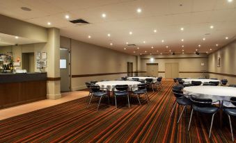 a large conference room with multiple tables and chairs arranged for a meeting or event at Nightcap at Gateway Hotel