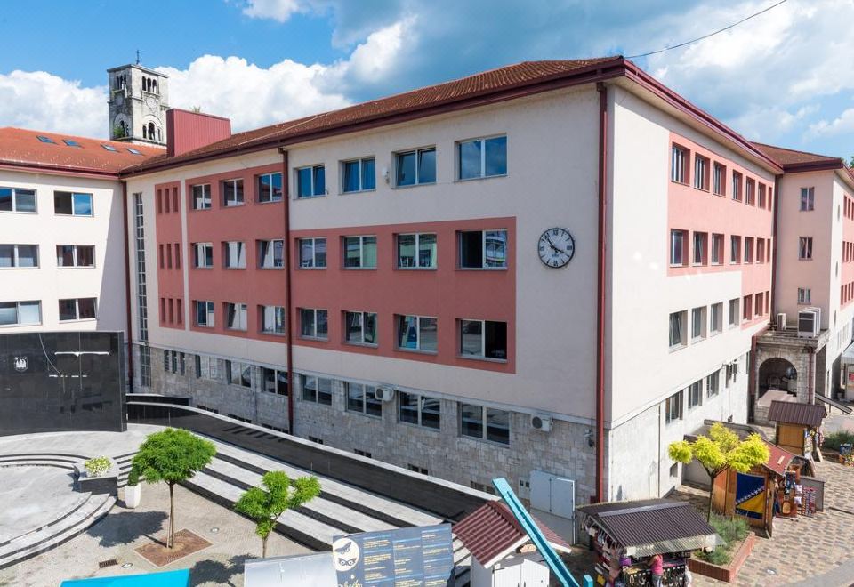a large building with a clock on the side is surrounded by a variety of buildings and trees at Suite Donna