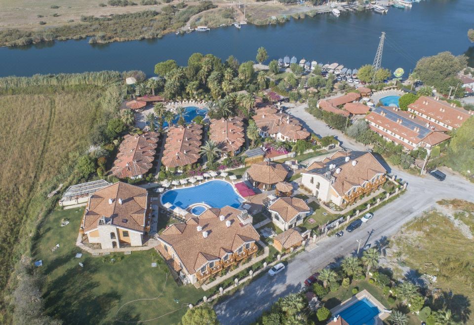 aerial view of a residential area near a body of water , featuring multiple apartment buildings and a swimming pool at Dalyan Live Spa Hotel