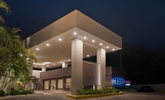 "a modern building with a large entrance and a sign that says "" home "". also potted plants in front of the building" at Emotions by Hodelpa - Juan Dolio