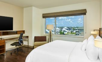 a hotel room with a large bed , a desk , and a window overlooking the ocean at Element Fargo