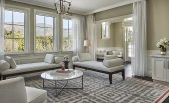 a spacious living room with white furniture , including a couch , chairs , and a coffee table at Rosewood Miramar Beach