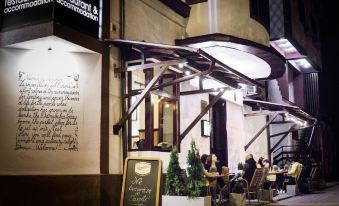 "a restaurant with people sitting at tables and a sign that says "" restaurant & comma "" in front of the building" at Nest