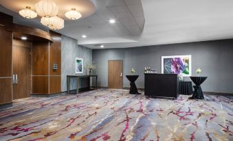 a modern hotel lobby with a gray carpet , white walls , and various pieces of furniture at Courtyard Omaha Bellevue at Beardmore Event Center