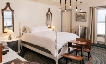 a bedroom with a large bed , two nightstands , and a lamp on each side of the bed at The Deers Head Inn Tavern