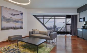 The living room features large windows that provide an outside view, with a couch positioned to face another area at Element Kuala Lumpur