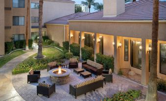 an outdoor patio with a fire pit surrounded by couches and chairs , creating a cozy atmosphere at Courtyard by Marriott Las Vegas Convention Center