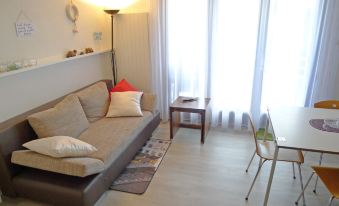 a cozy living room with a couch , a chair , and a dining table in front of a window at Annex