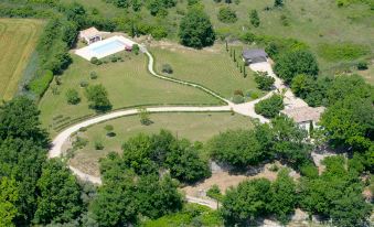 a bird 's eye view of a house surrounded by trees and greenery with a driveway at Les Cotes