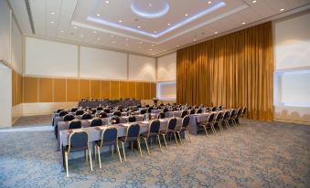 a large conference room with rows of chairs arranged in a semicircle , ready for a meeting or event at Mediterranean Beach Hotel