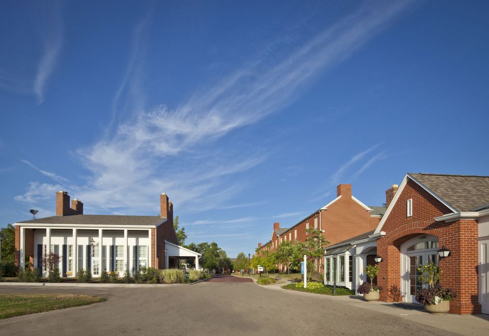 a row of brick houses with white trim , situated in front of a blue sky with white clouds at Nationwide Hotel and Conference Center