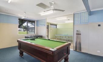 a pool table with a green felt surface is in the middle of a room at Discovery Parks - Bunbury