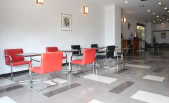 a room with a dining table and several chairs arranged in a row , along with a refrigerator at Sakuraya