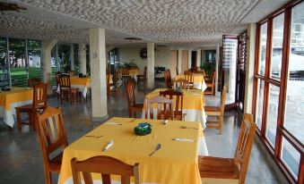 a large , empty banquet hall with multiple dining tables and chairs arranged for a gathering at Hotel Laguna Bacalar