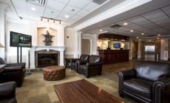 a spacious living room with a fireplace and a tv , featuring two brown leather couches and a wooden coffee table at Hotel Arctic