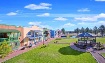 a large , colorful building with a grassy field in front of it and a blue sky above at WorldMark Bison Ranch