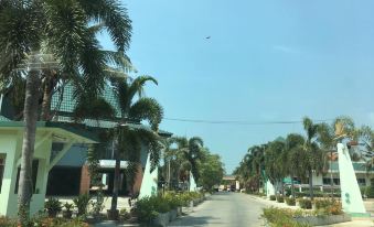 a street view of a city with palm trees and buildings , under a clear blue sky at Rawanda Resort