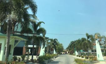 a street view of a city with palm trees and buildings , under a clear blue sky at Rawanda Resort Hotel