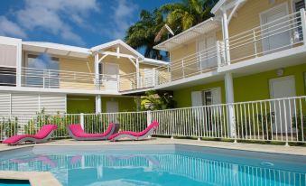 a swimming pool and a building with balconies , surrounded by palm trees and clear blue skies at Majesty Palm