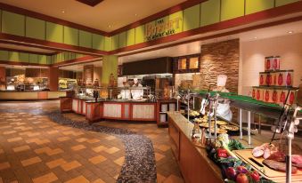 a busy buffet restaurant with multiple dining tables and chairs , as well as a buffet of various food items at Mount Airy Casino Resort - Adults Only 21 Plus